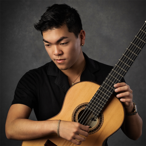 A headshot of David Dung posing with his classical guitar