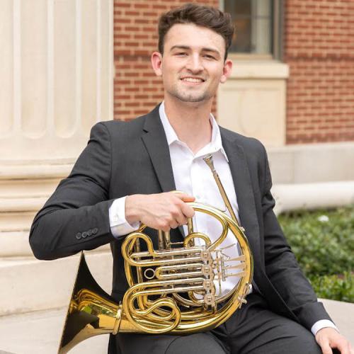 A headshot of Lucas Hamilton with his horn