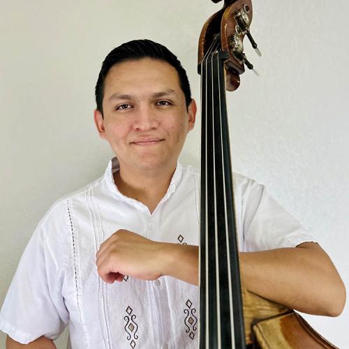 a headshot of Andres Hernandez with his bass.
