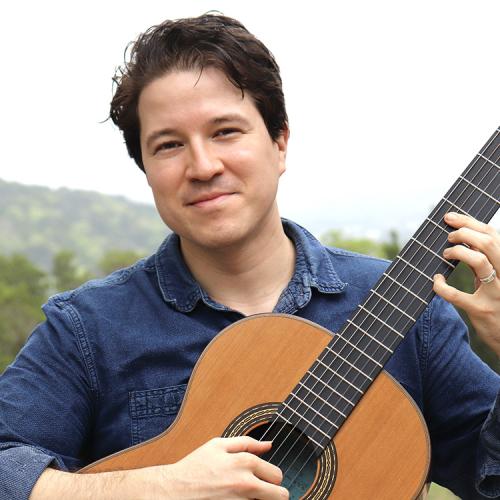 A headshot of Ian Wasdin, holding his guitar