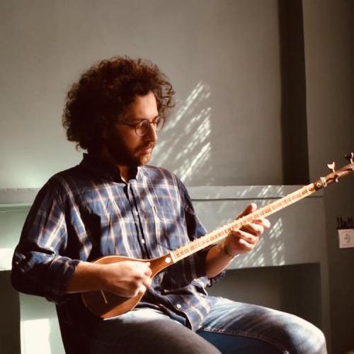 A headshot of Hamidreza Fallahi as he plays an oud. 