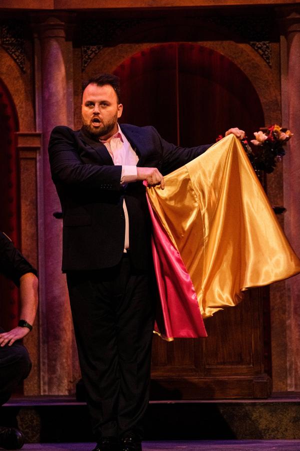 A matador flaunts his multi-colored cape for onlookers