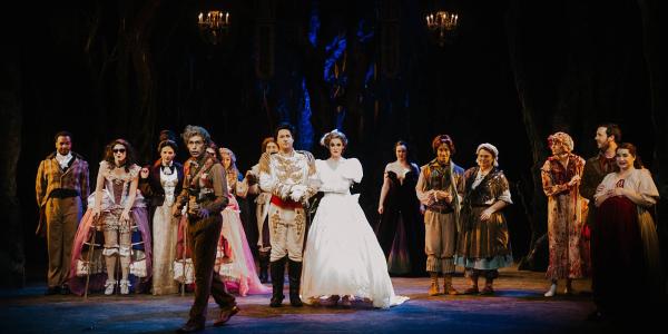 the Cast of into the woods stand on stage, ready for the curtain call