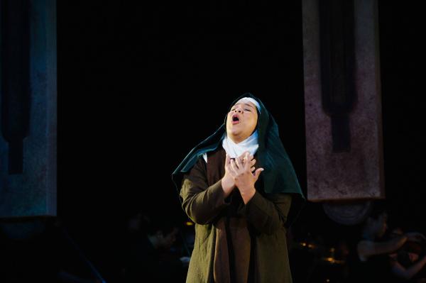 A nun holds her hands over her heart as she cries out to the heavens.