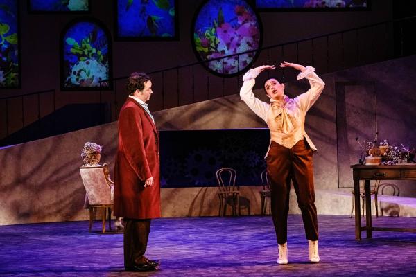 A man in a velvet overcoat watches a woman pirouette awkwardly across stage as she impersonates the movements of Hoffman's steam-punk robot girl.