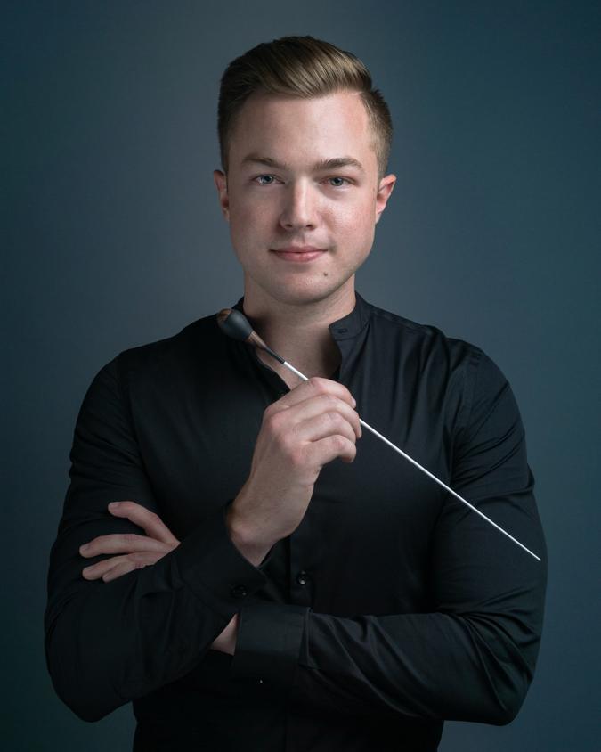 a headshot of Drew Eary holding a conducting baton