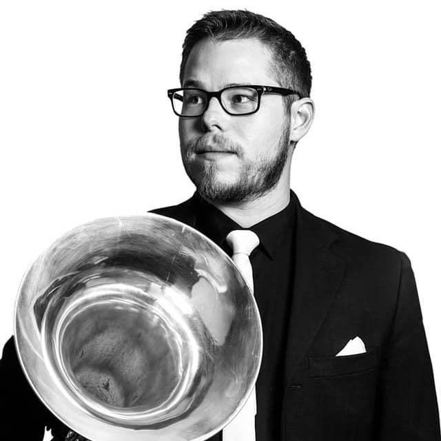 A headshot of Alex Avila, holding his tuba.