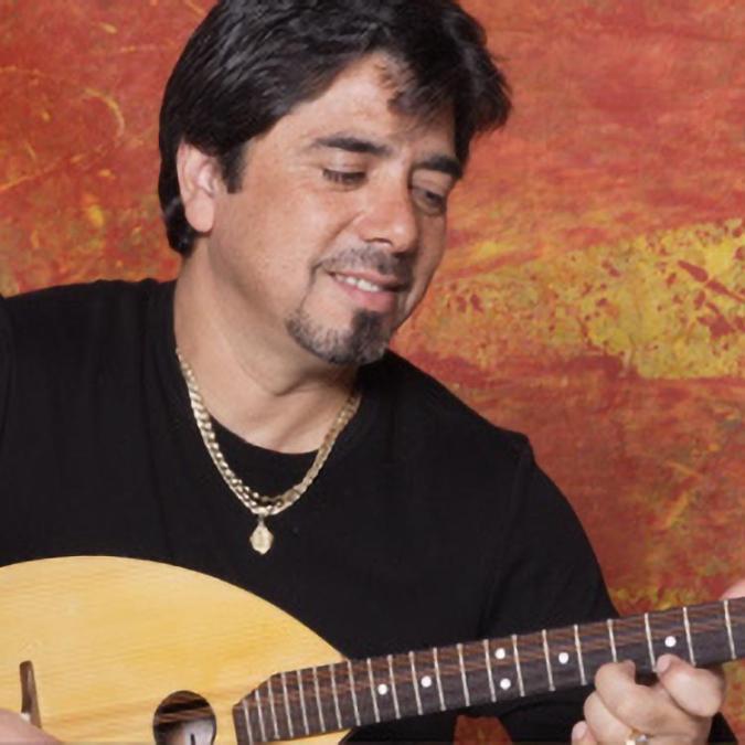 a headshot of Rumen Shopov playing an oud.