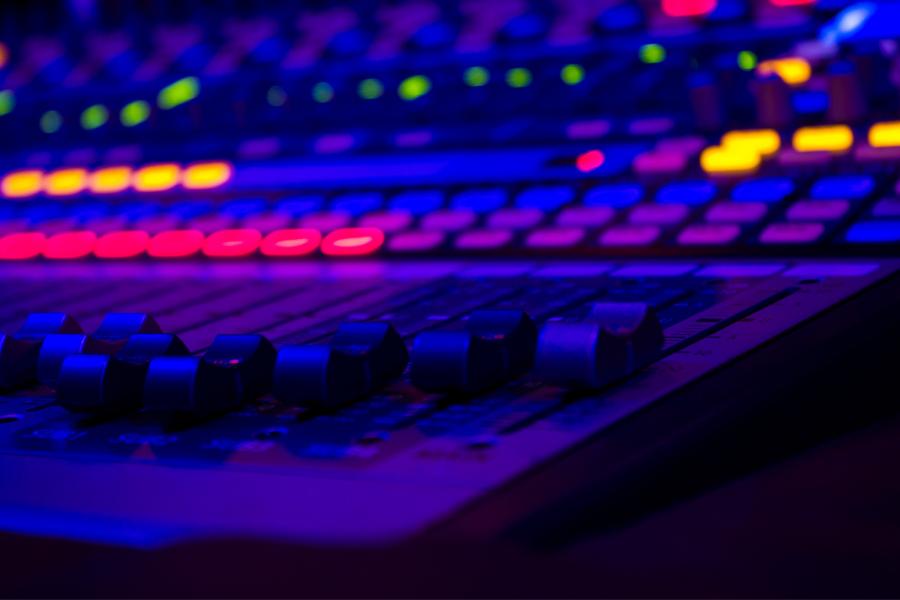 a close up of a mixing board, with lots of glowing lights