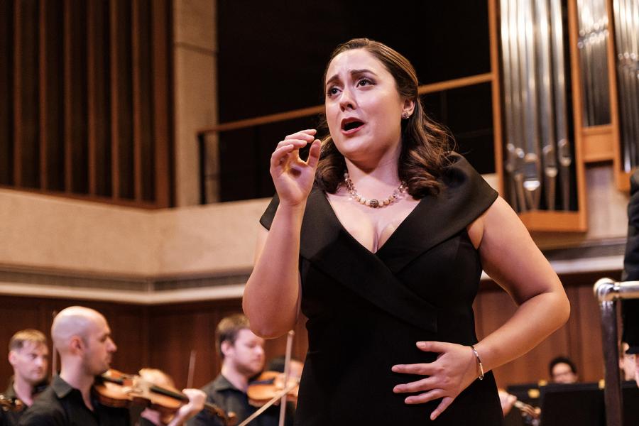 A soprano sings dramatically with an orchestra behind her