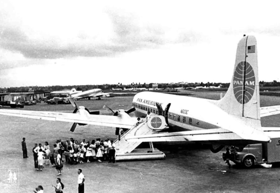 Black and white archival image of people getting on plane