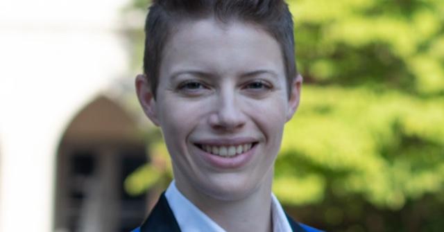 Headshot of tuba player Gretchen Renshaw standing outside in front of a tree.