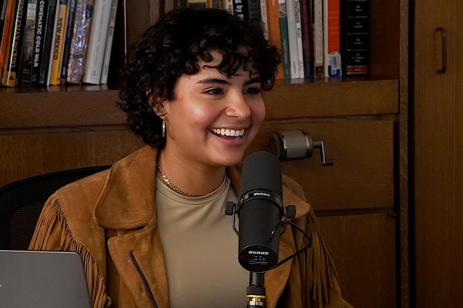 Ailish F. Quiñones Rivera sitting behind a mic