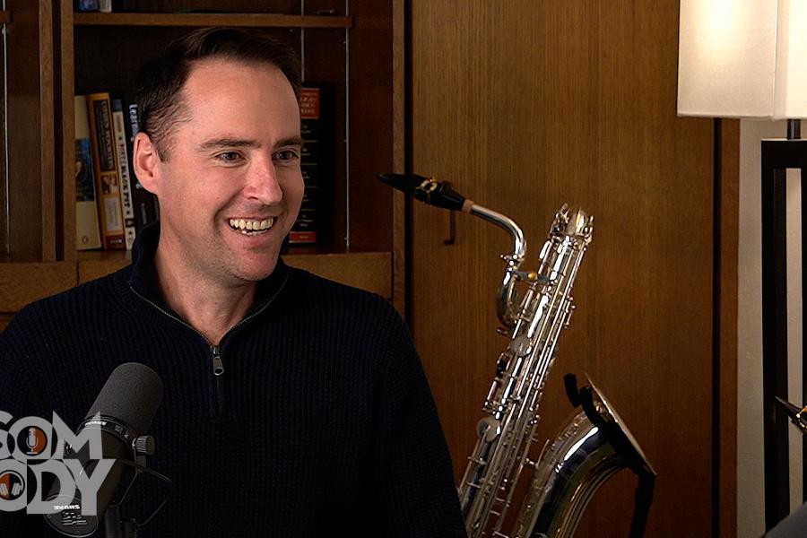 Stephen Page sitting in an office with a Sax behind him