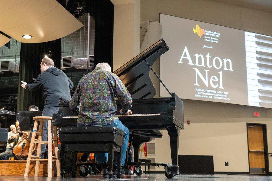 Anton Nel Playing the piano on the stage with a screen behind him that says "Anton Nel"