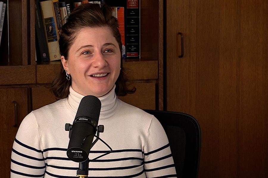 Sophio Dzidziguri talking into a mic in front of a bookshelf