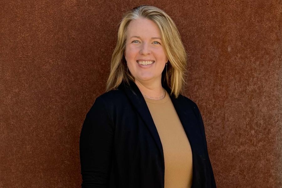 Holly Dalrymple standing in front of a brown background