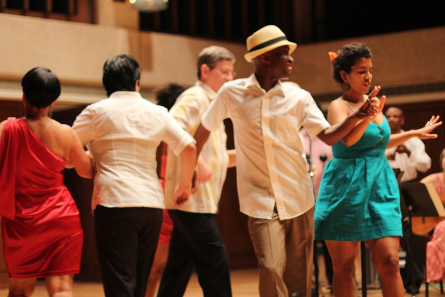 members of the Hispanic Caribbean Ensemble dance on stage during a performance