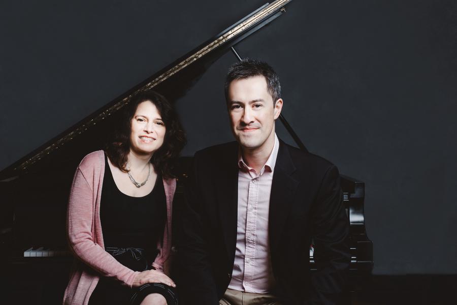 Patti Wolf and Andrew Brownell sit together on at a piano 