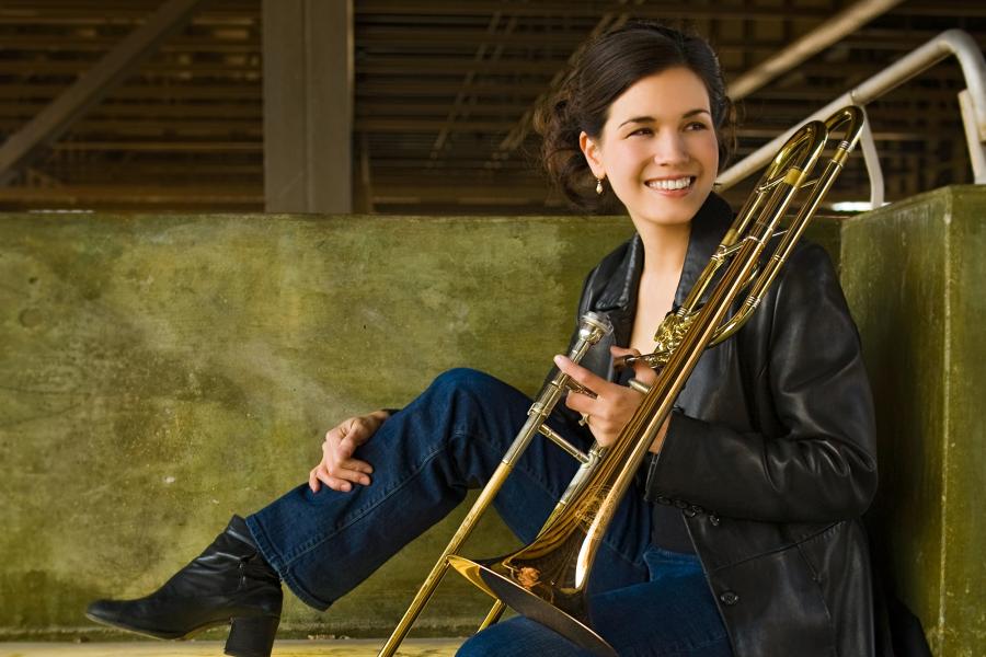 Marcia Medrano poses with her trombone, smiling past the camera