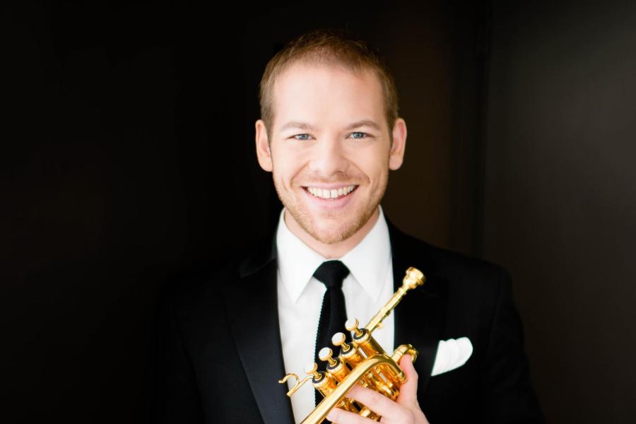 Caleb Hudson holding a golden trumpet.