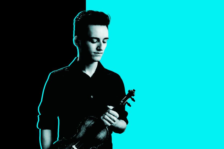 Black and white photo of a student holding a violin in front of a black and aqua background.