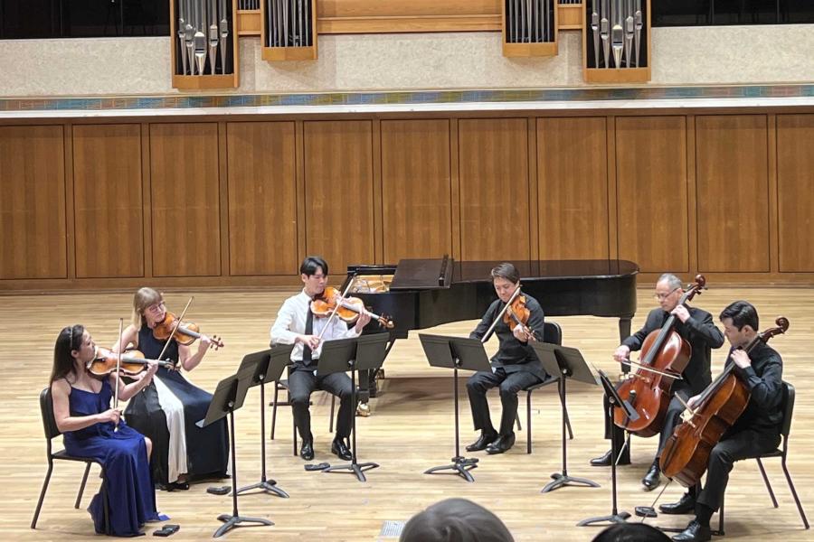 A small musical ensemble plays on a stage