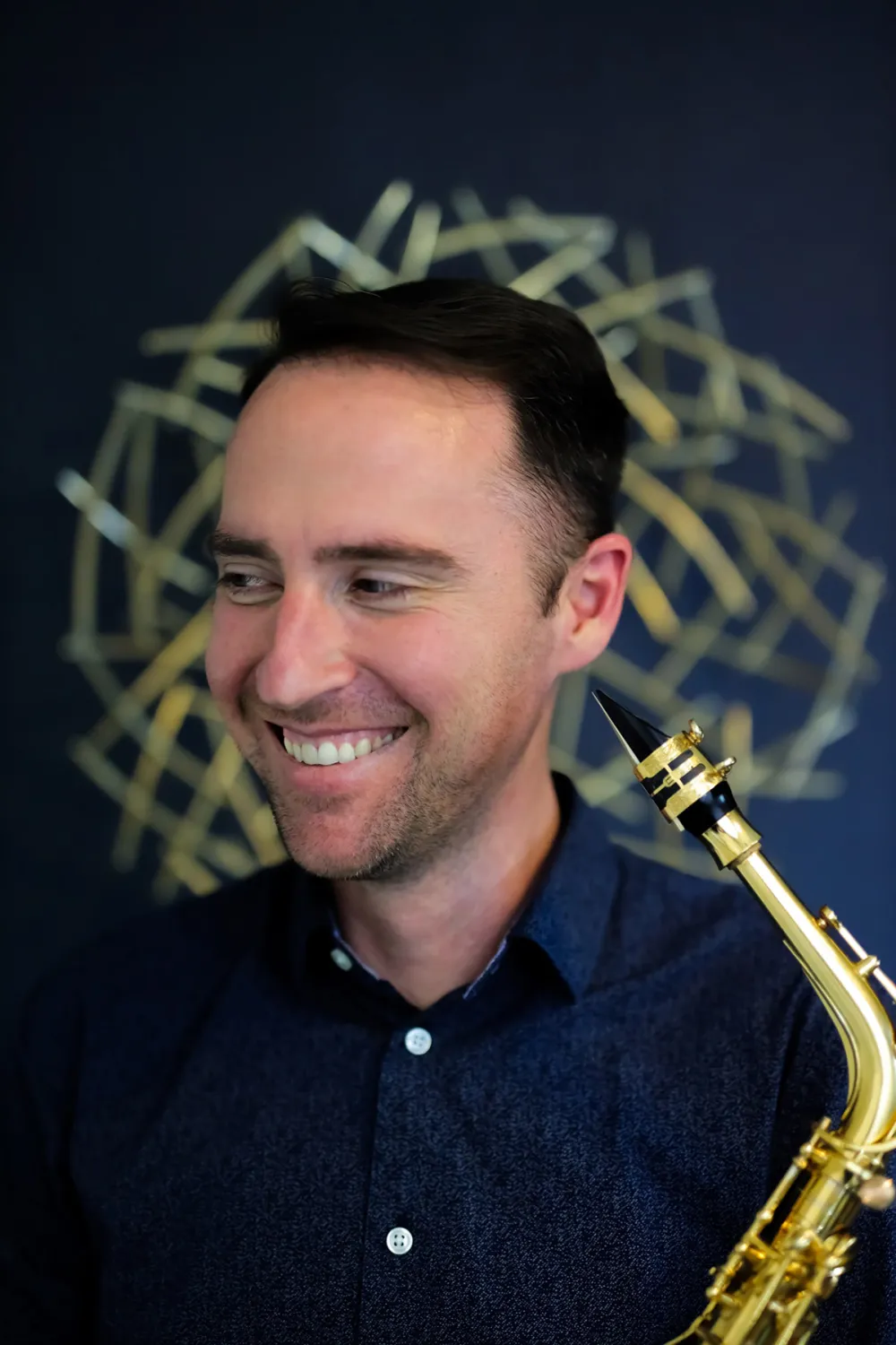 Stephen Page standing holding a horn