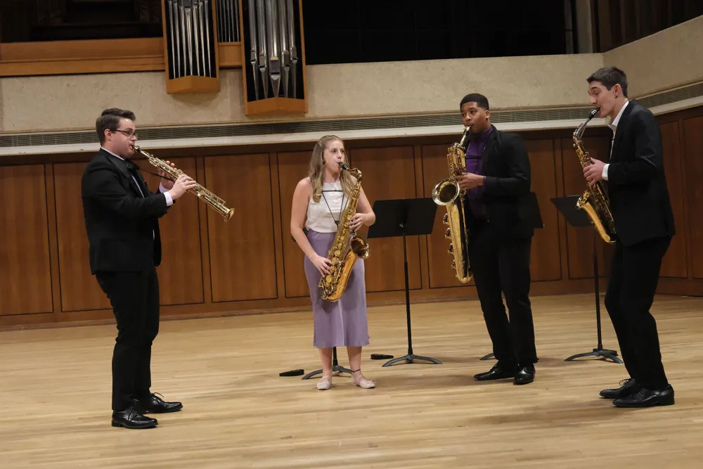 4 Sax players playing on stage