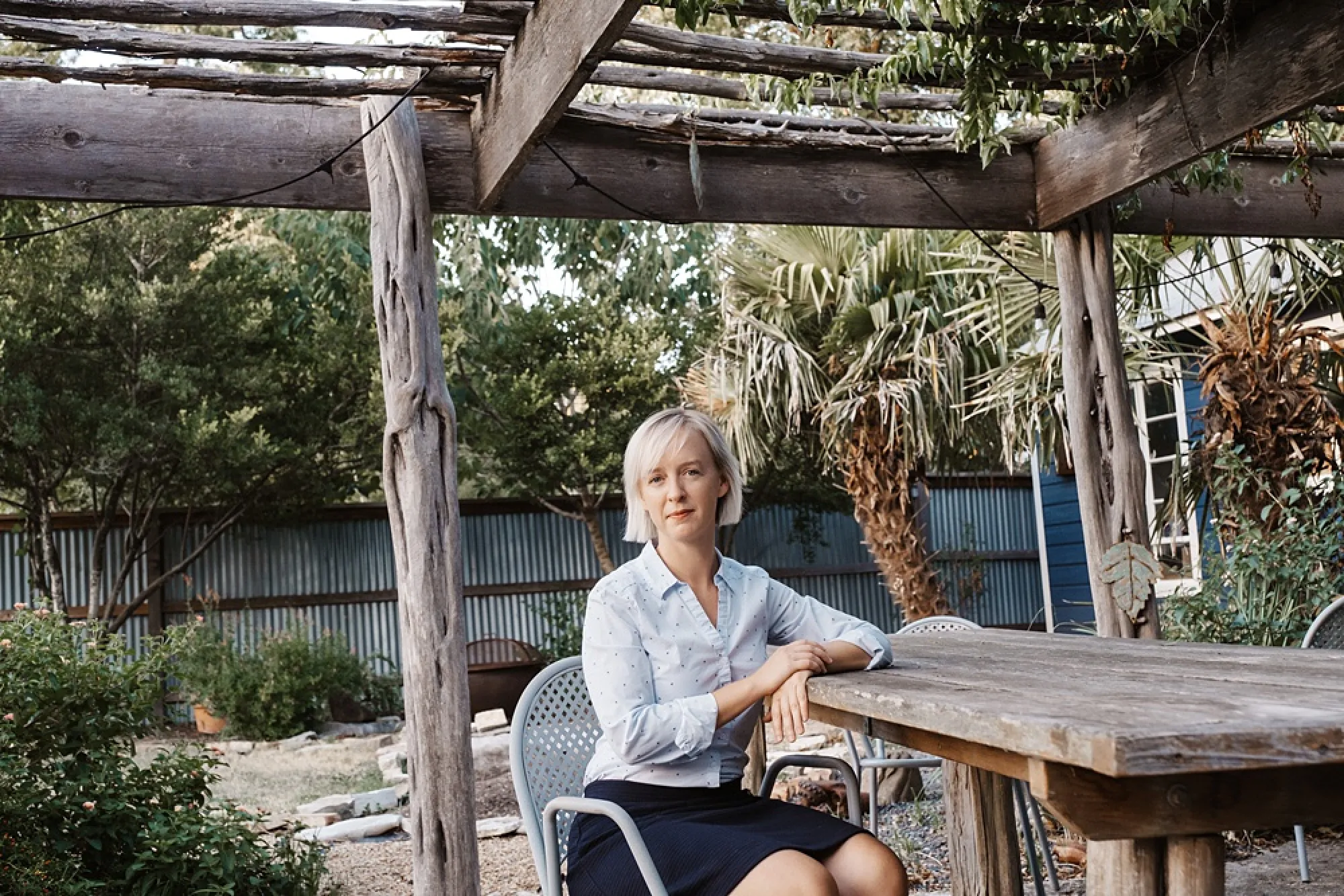 Photo of Chelsea Burns under a pergola at her home in Austin