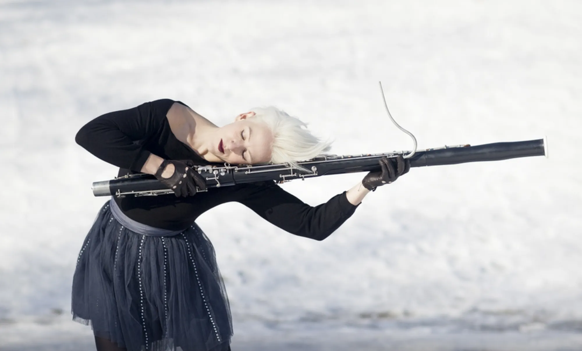 Rebekah Heller poses with her head resting on a bassoon; Photo by Carrie Schneider