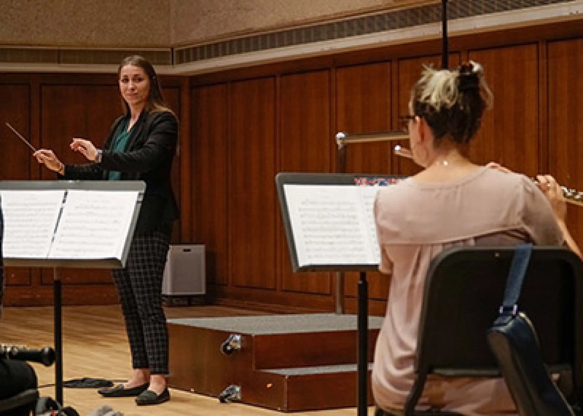 Woman conducting woman playing flute
