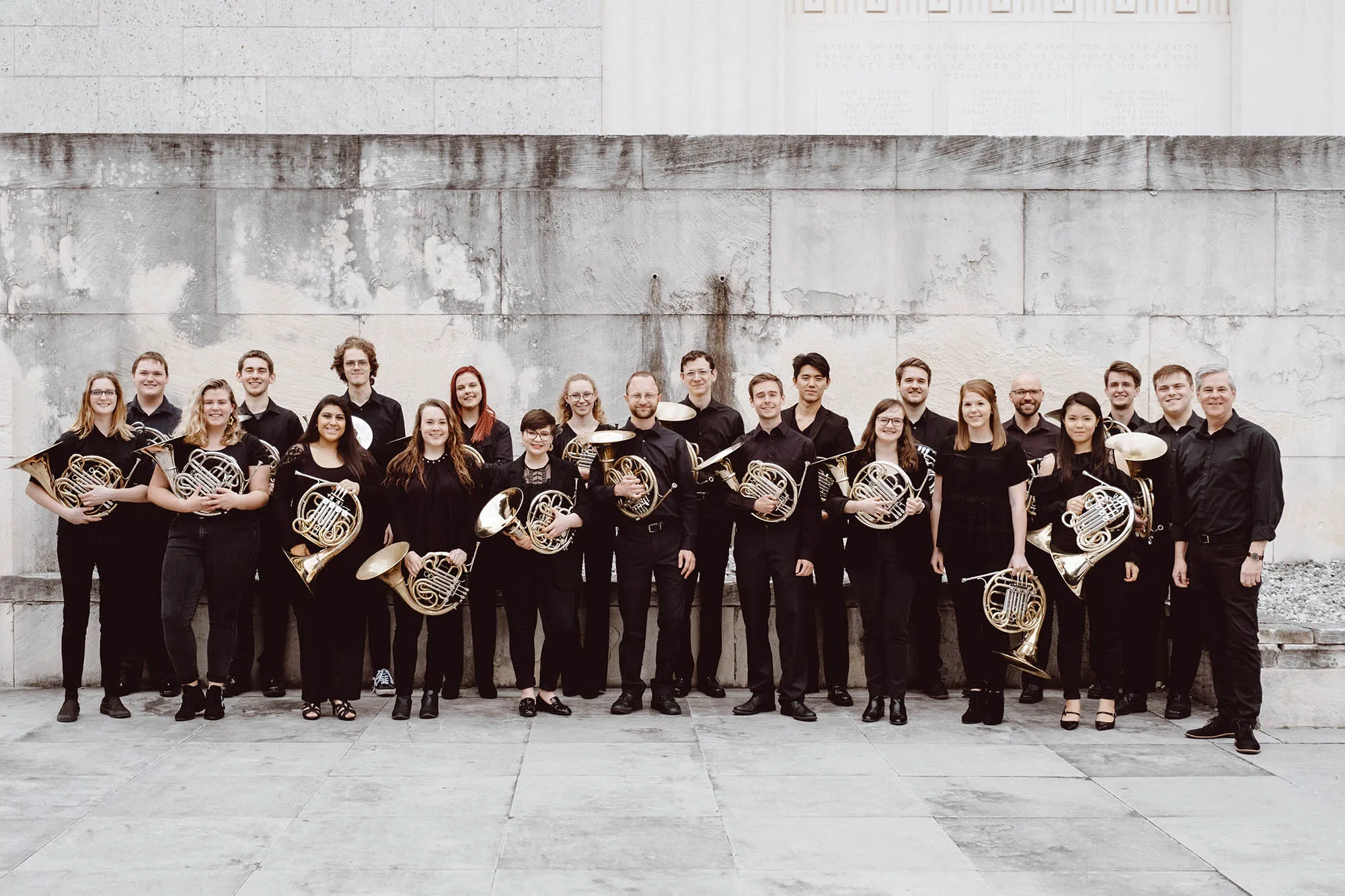 the 2019 horn studio with their horns, in a white stone courtyard.
