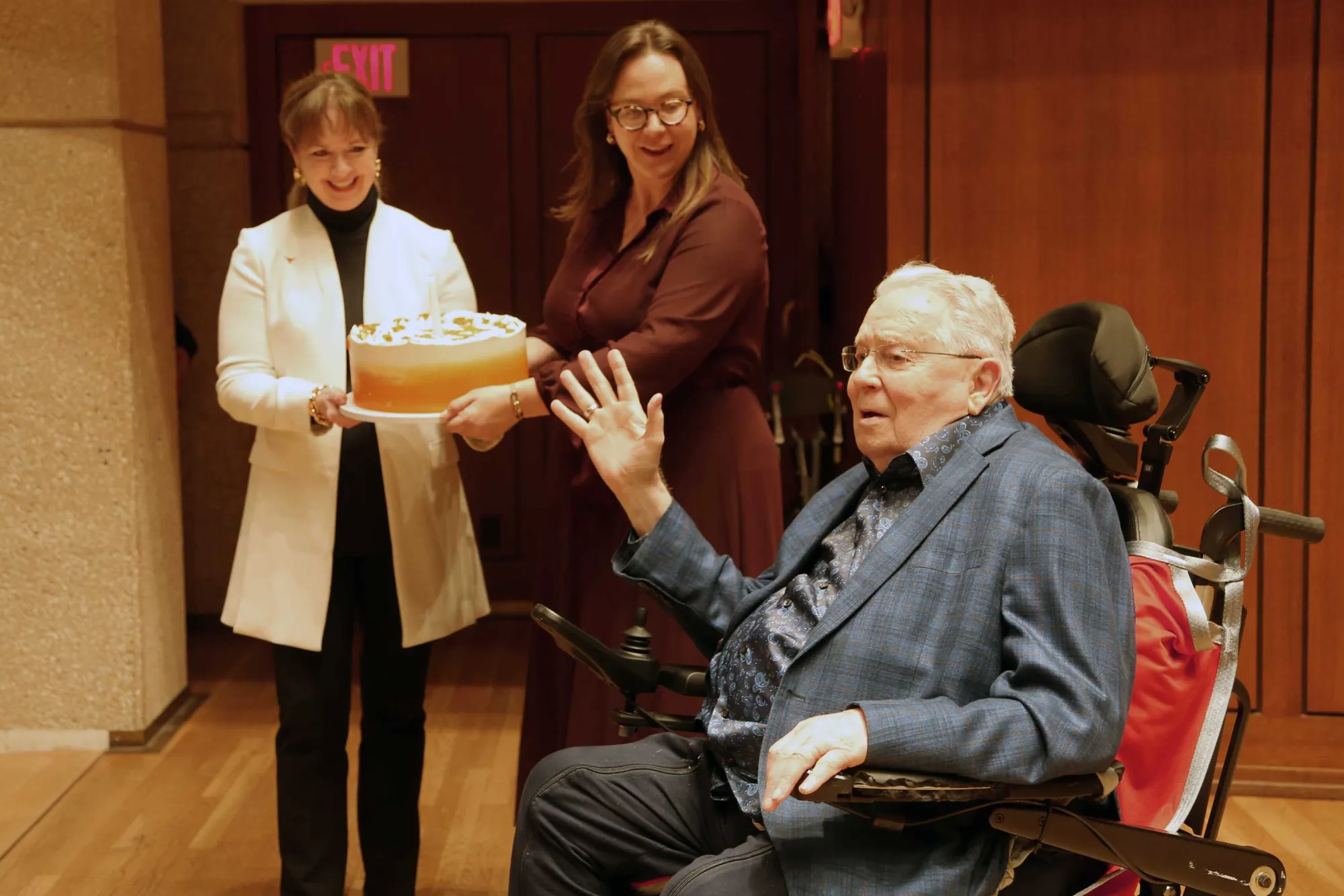 Joe Long waving to the crowd while getting a birthday cake onstage