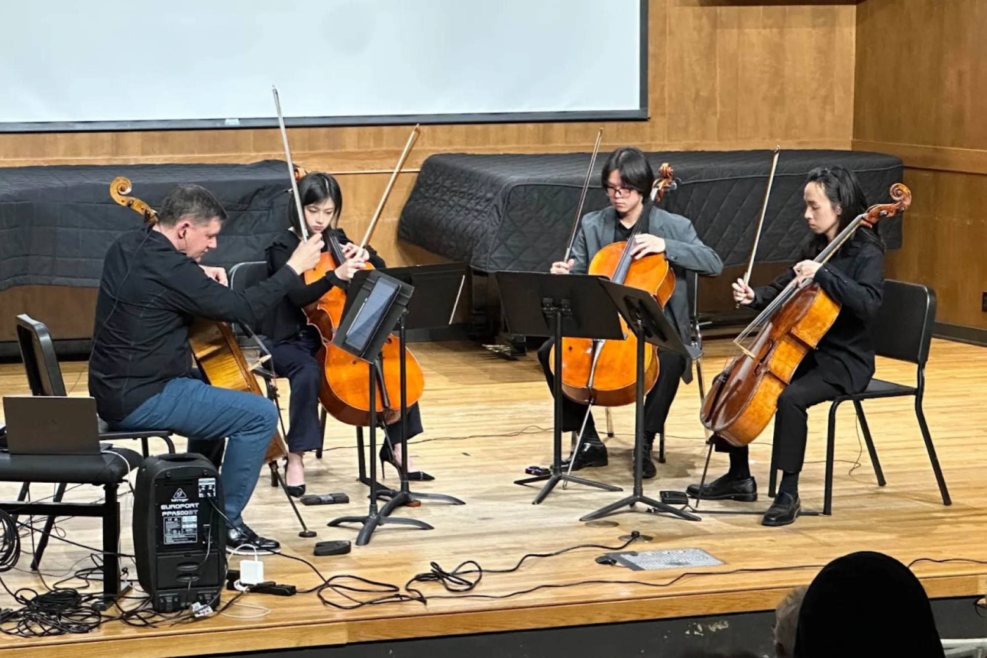 Cellist Nick Photinos and four other cellists perform on stage