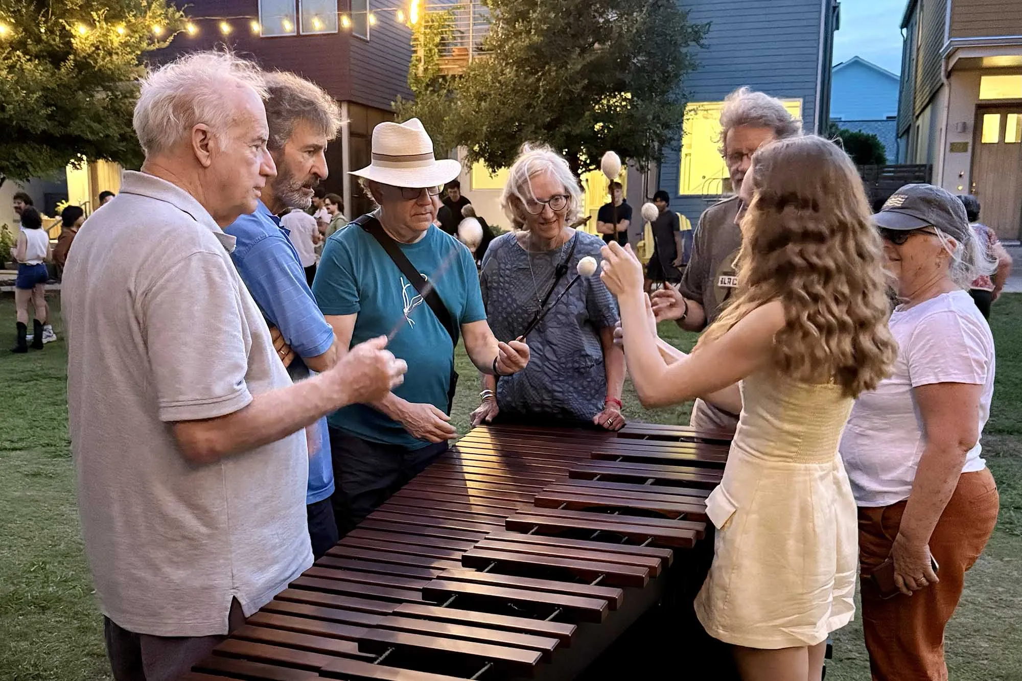 People standing outside around a marimba