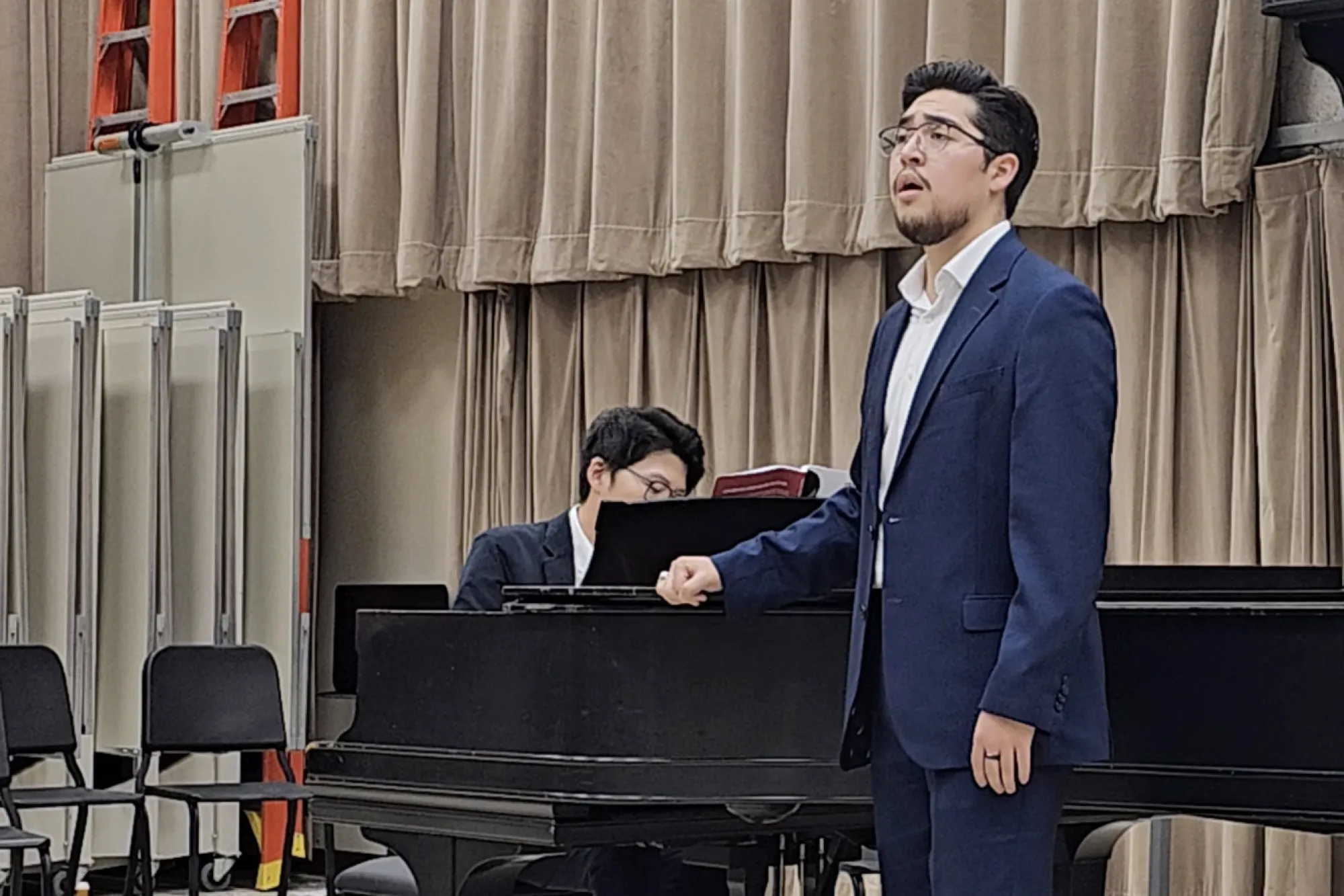 Nathaniel Payan singing with a piano in the background