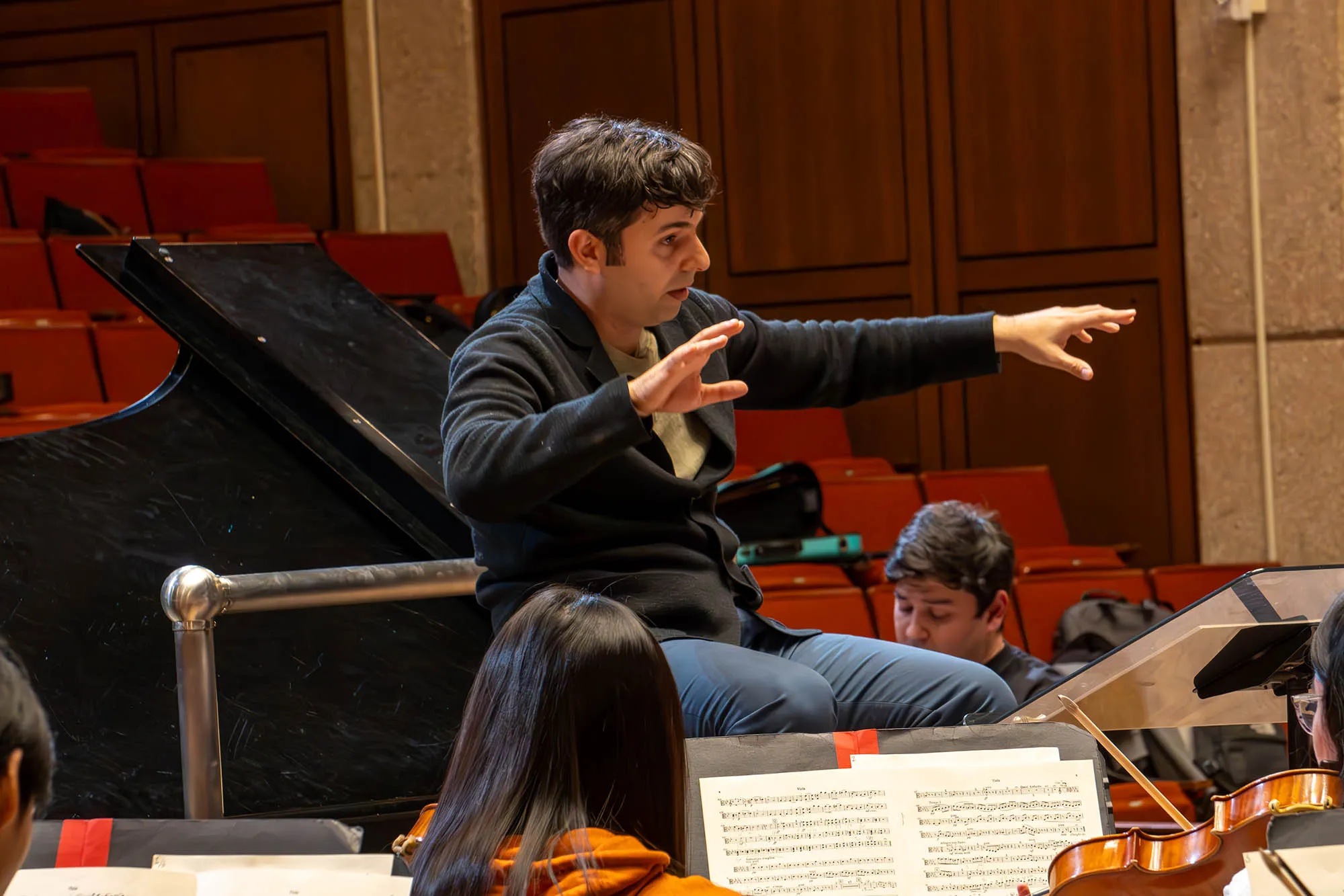 conductor  Farkhad Khudyev with Behzod Abduraimov on piano on stage with an orchestra