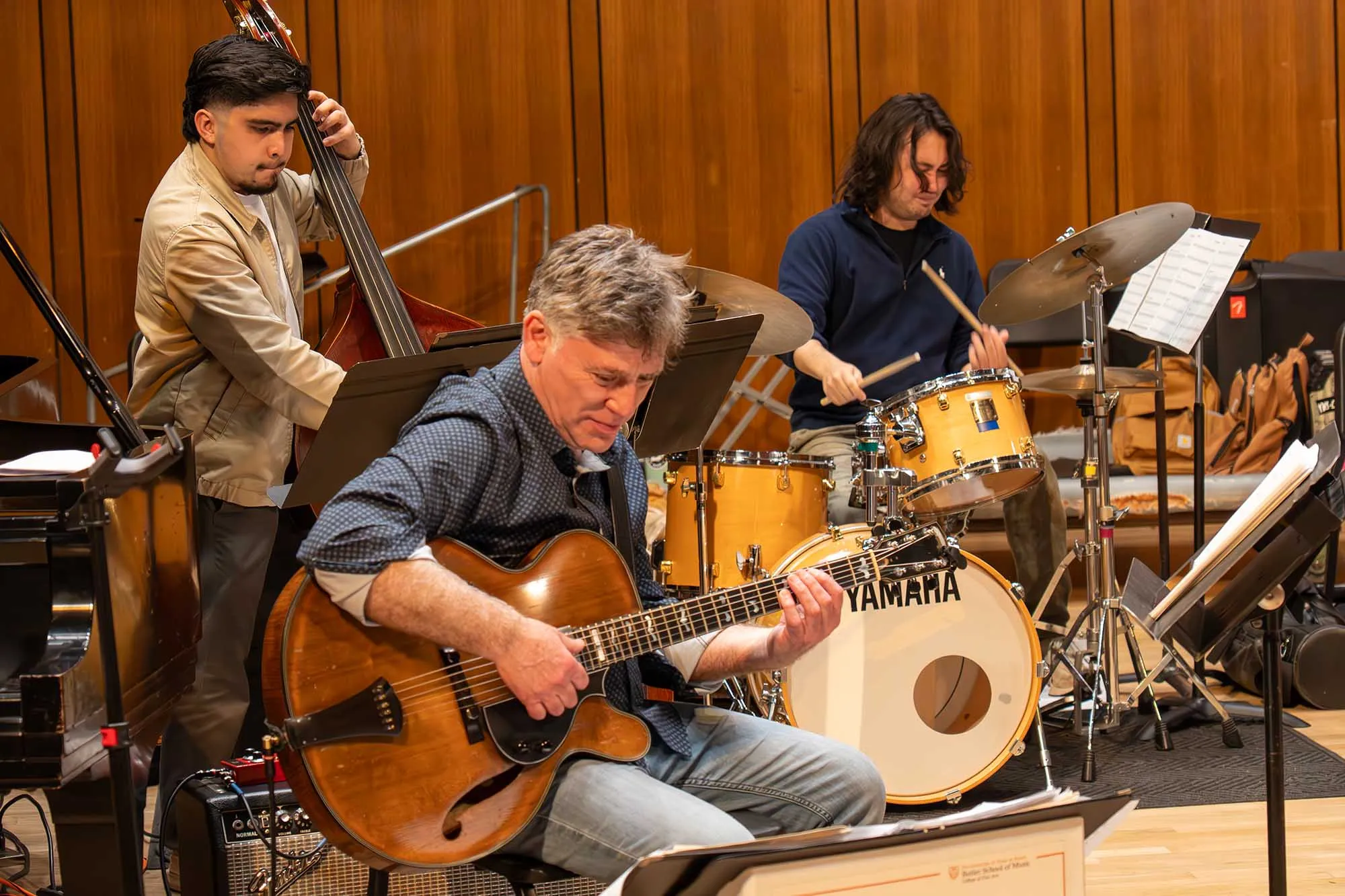 Guitarist Peter Bernstein playing on stage with a drummer and bass player in the background