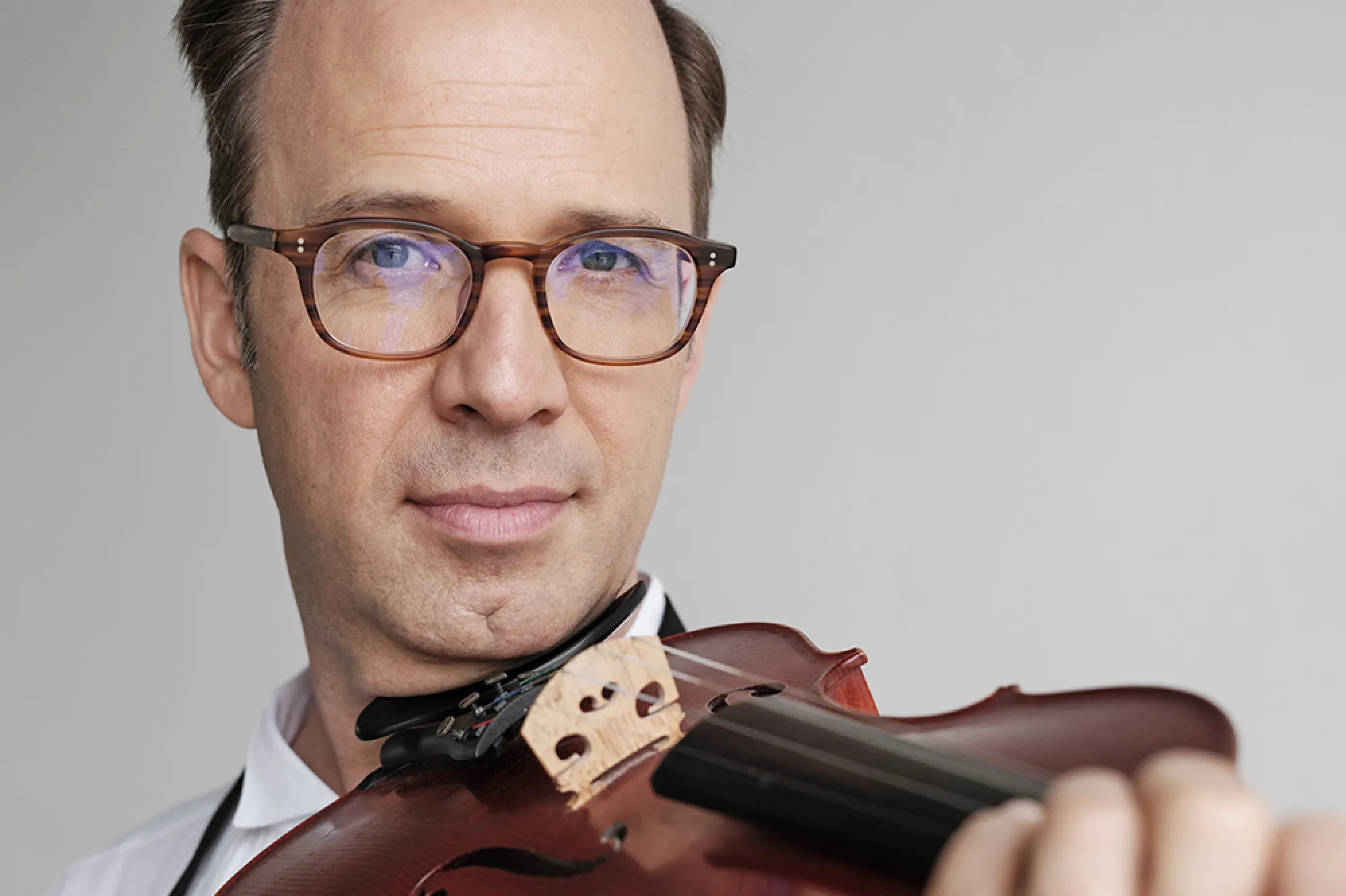 Man holding a violin with a white background