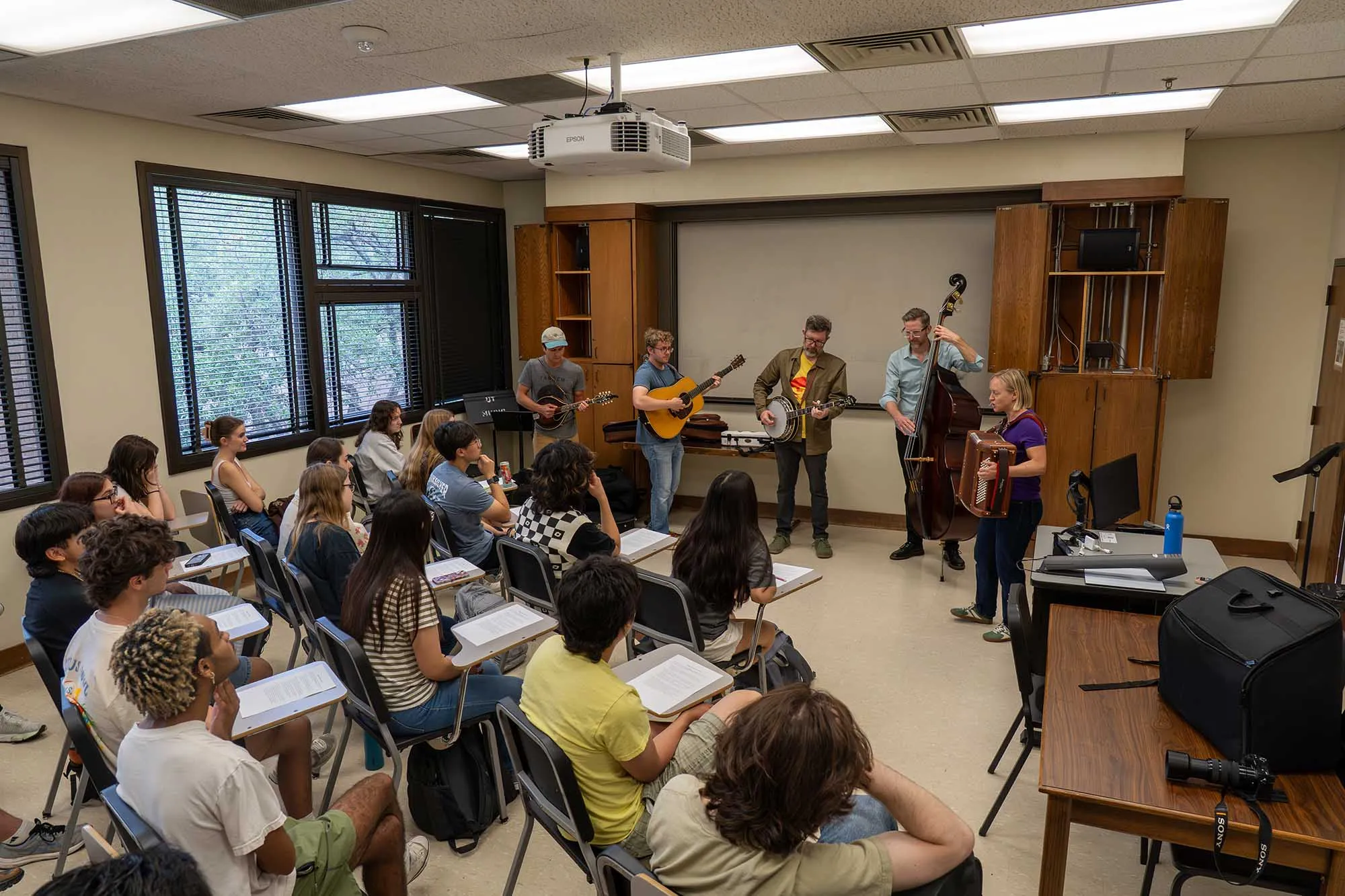 A bluegrass band plays in a classroom to students