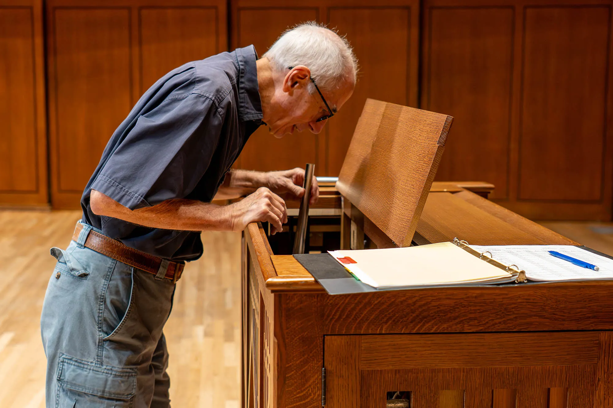 A person is repairing a small pipe organ