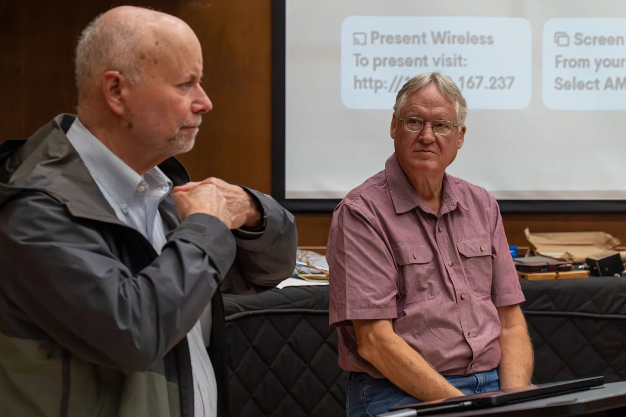 Ken Eschete and Dale Erwin explain about pianos with a screen in the background