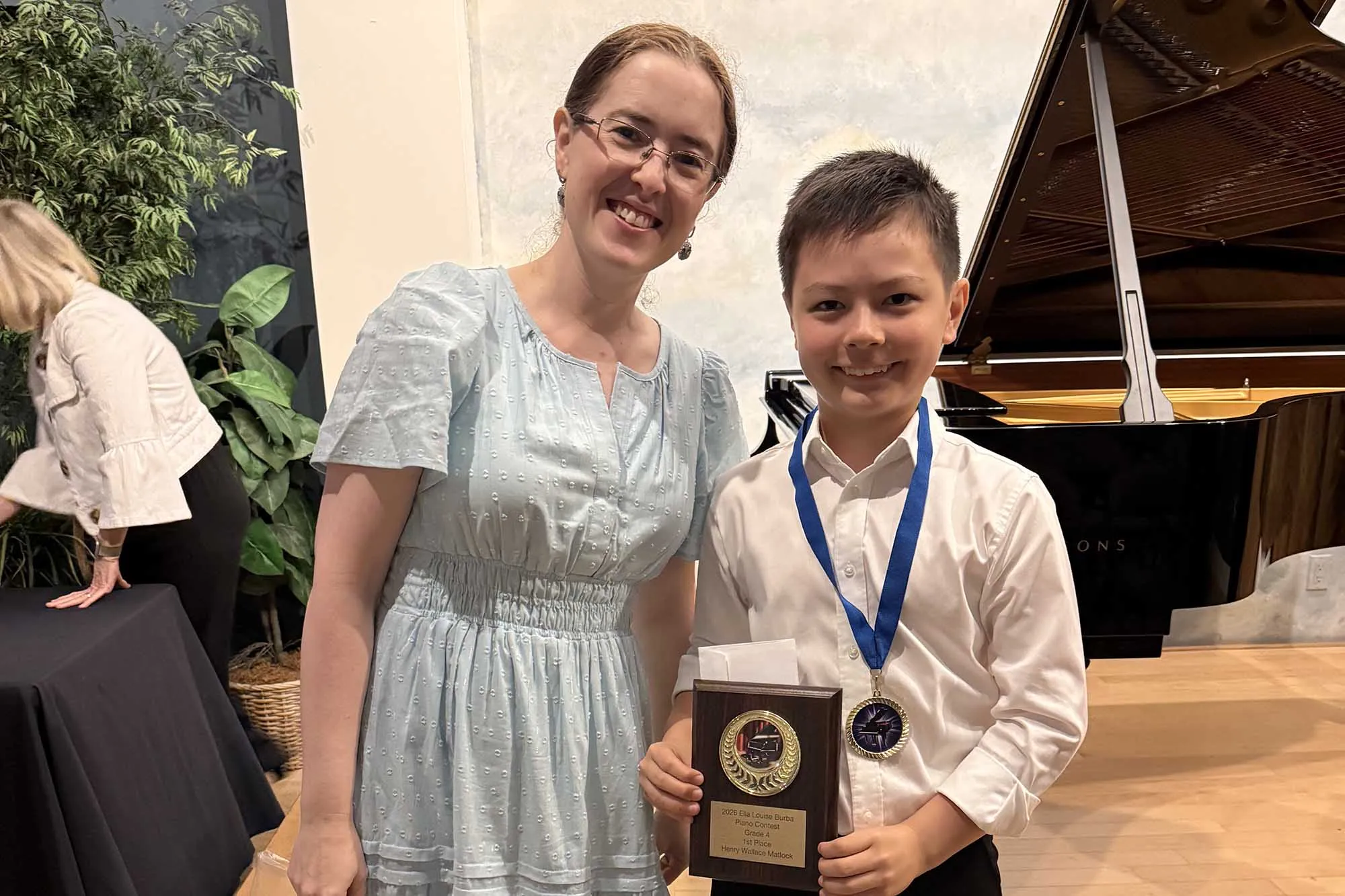 Margarita Denenburg standing next to a student while holding an award