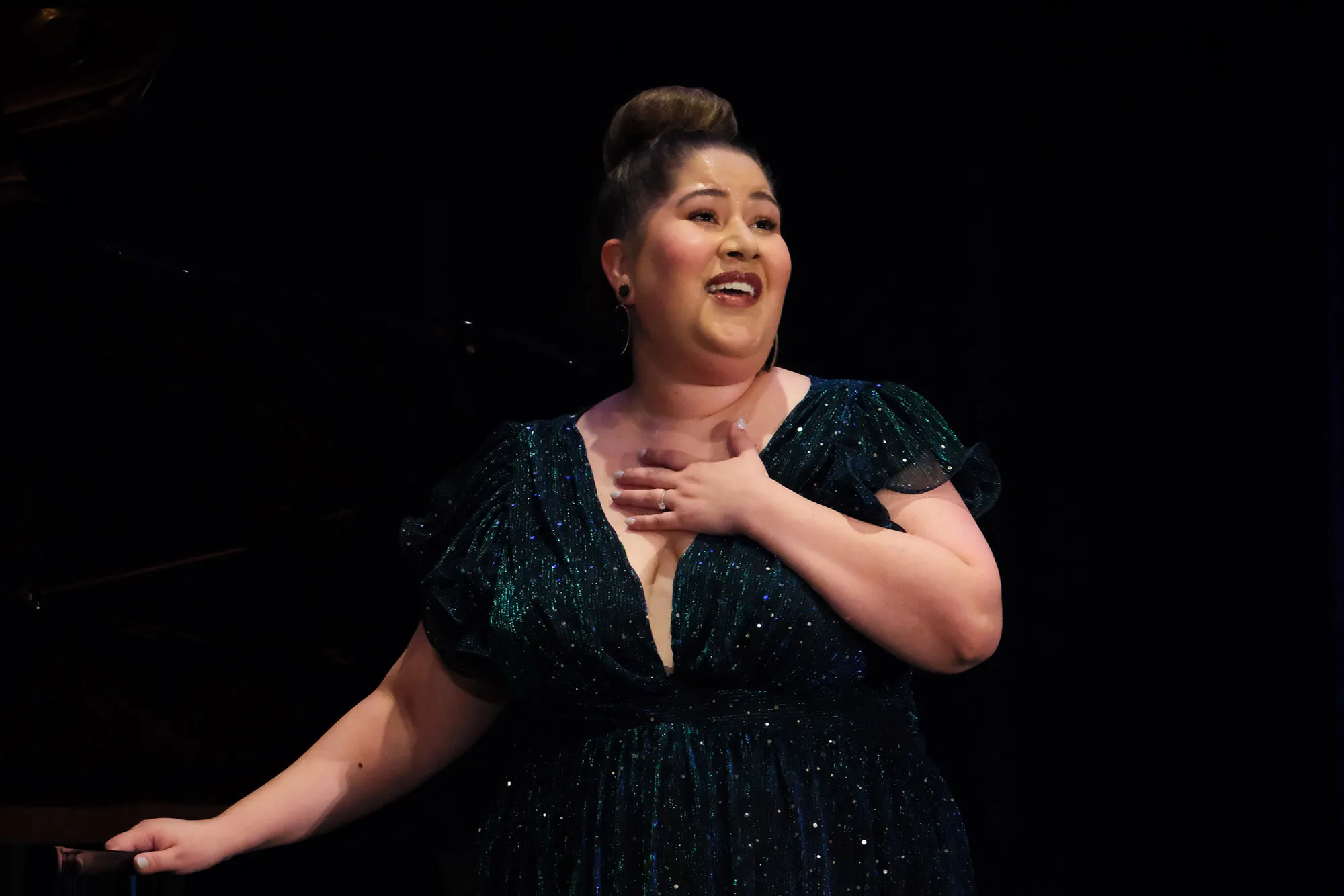 Lily Guerrero singing in front of a black background