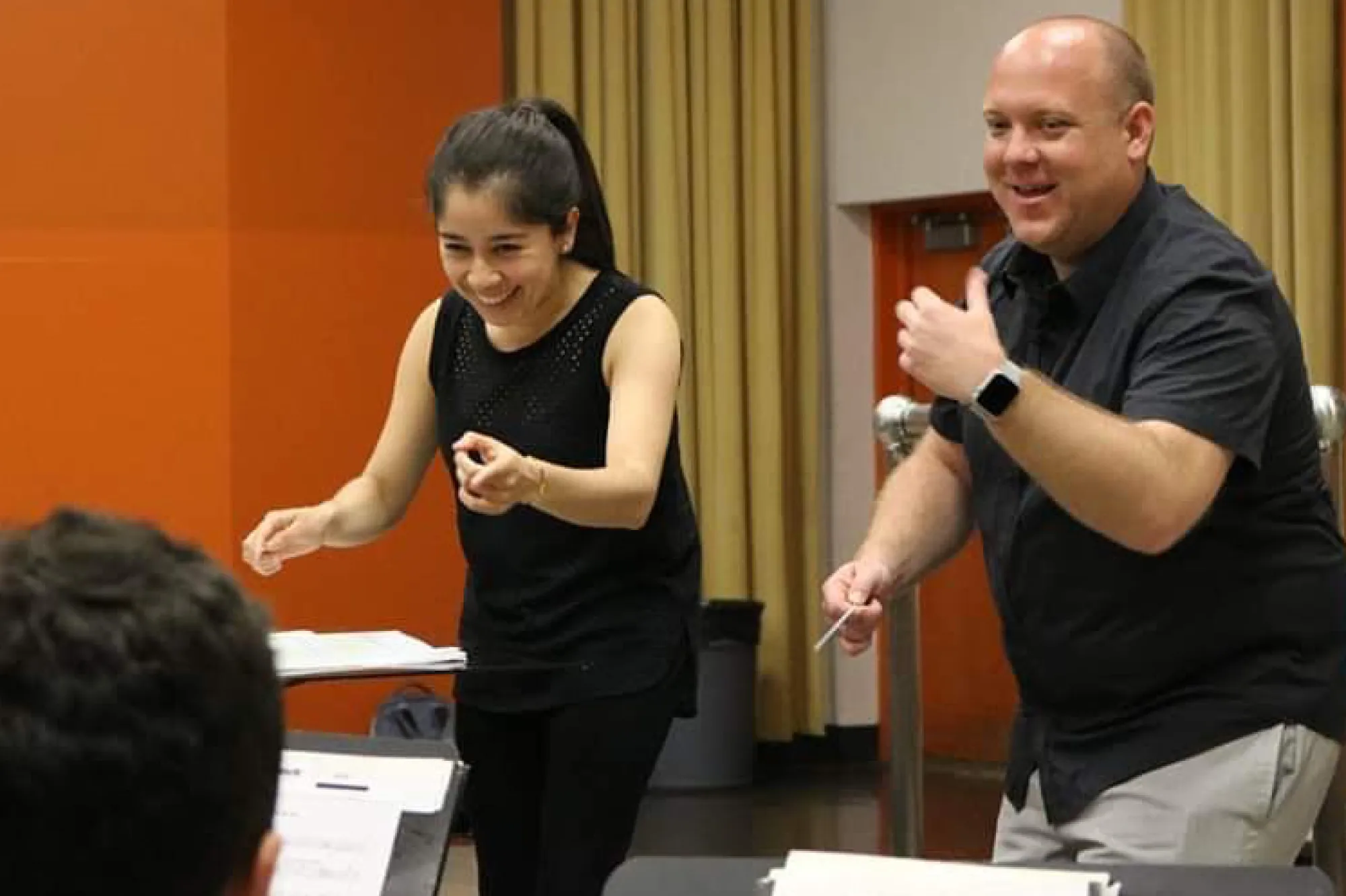 Two people conducting a musical ensemble