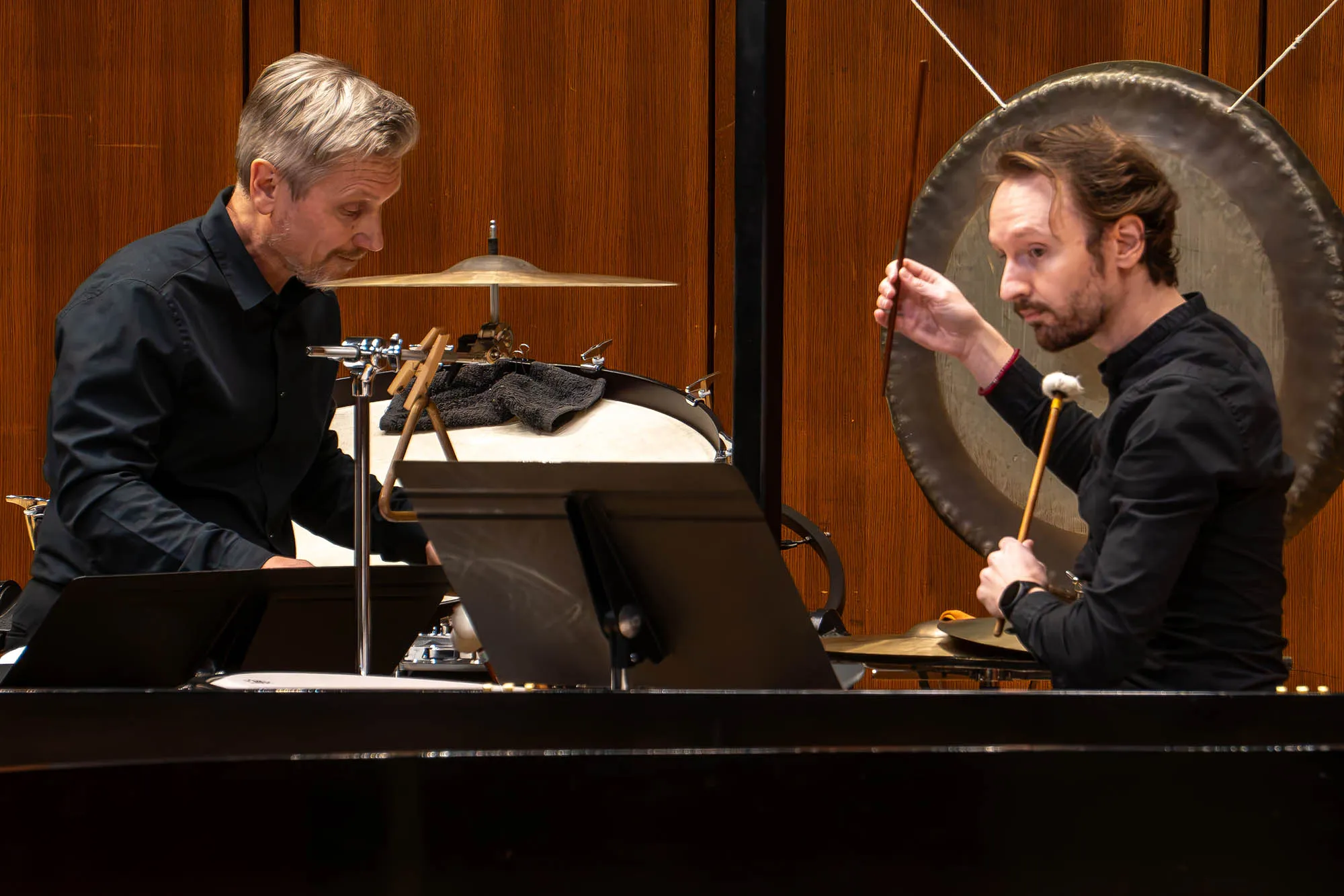 Two classical percussion players perform on stage