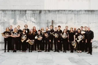 the ut horn choir hold their instruments