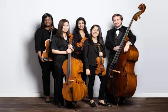 a group of string players with their instruments in concert attire