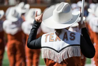 Longhorn Band member gives hook 'em horns sign